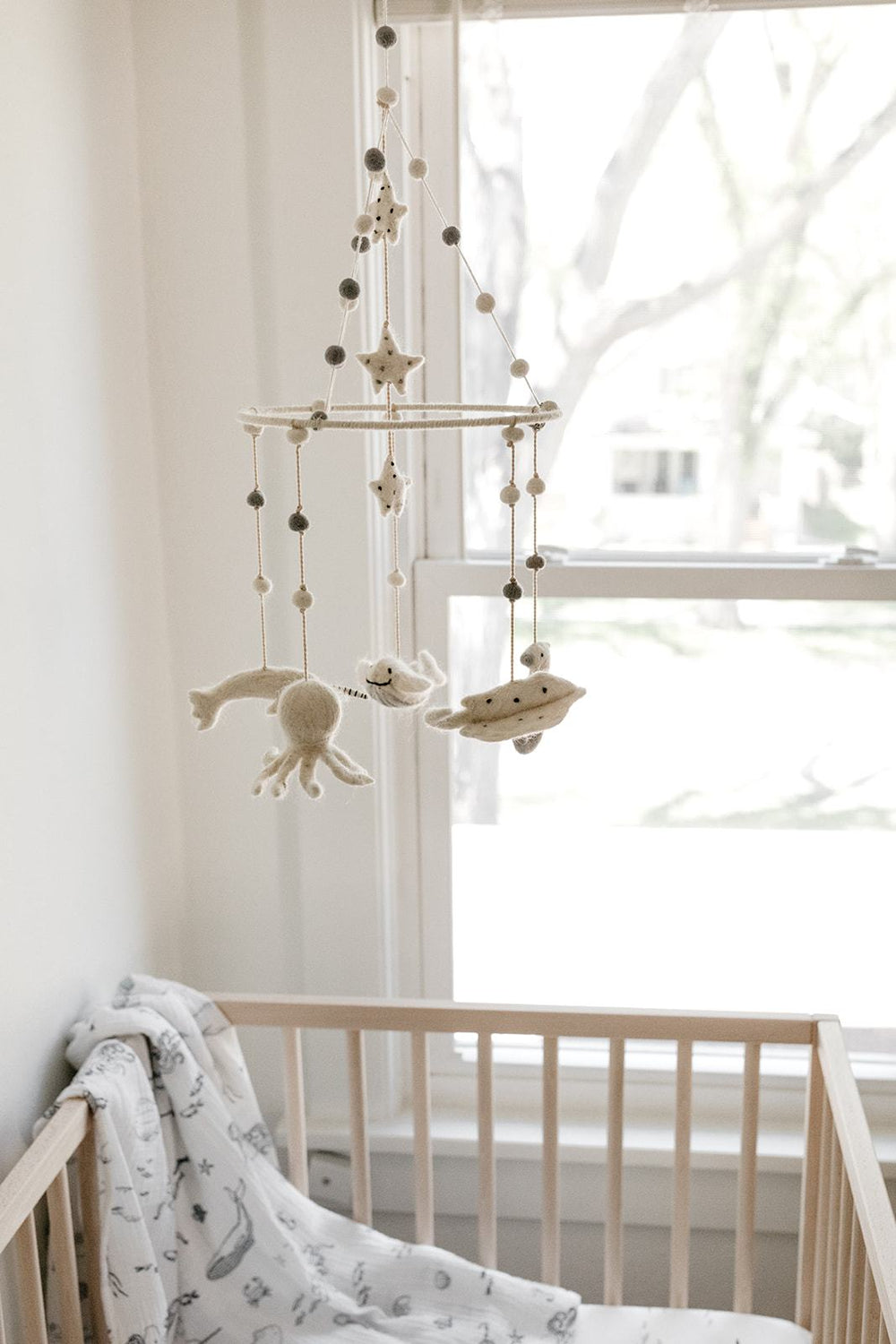 Pehr Life Aquatic Mobile over Baby Crib. Ethically Handmade using 100% wool and AZO-Free dyes. Mobile with sea creatures.
