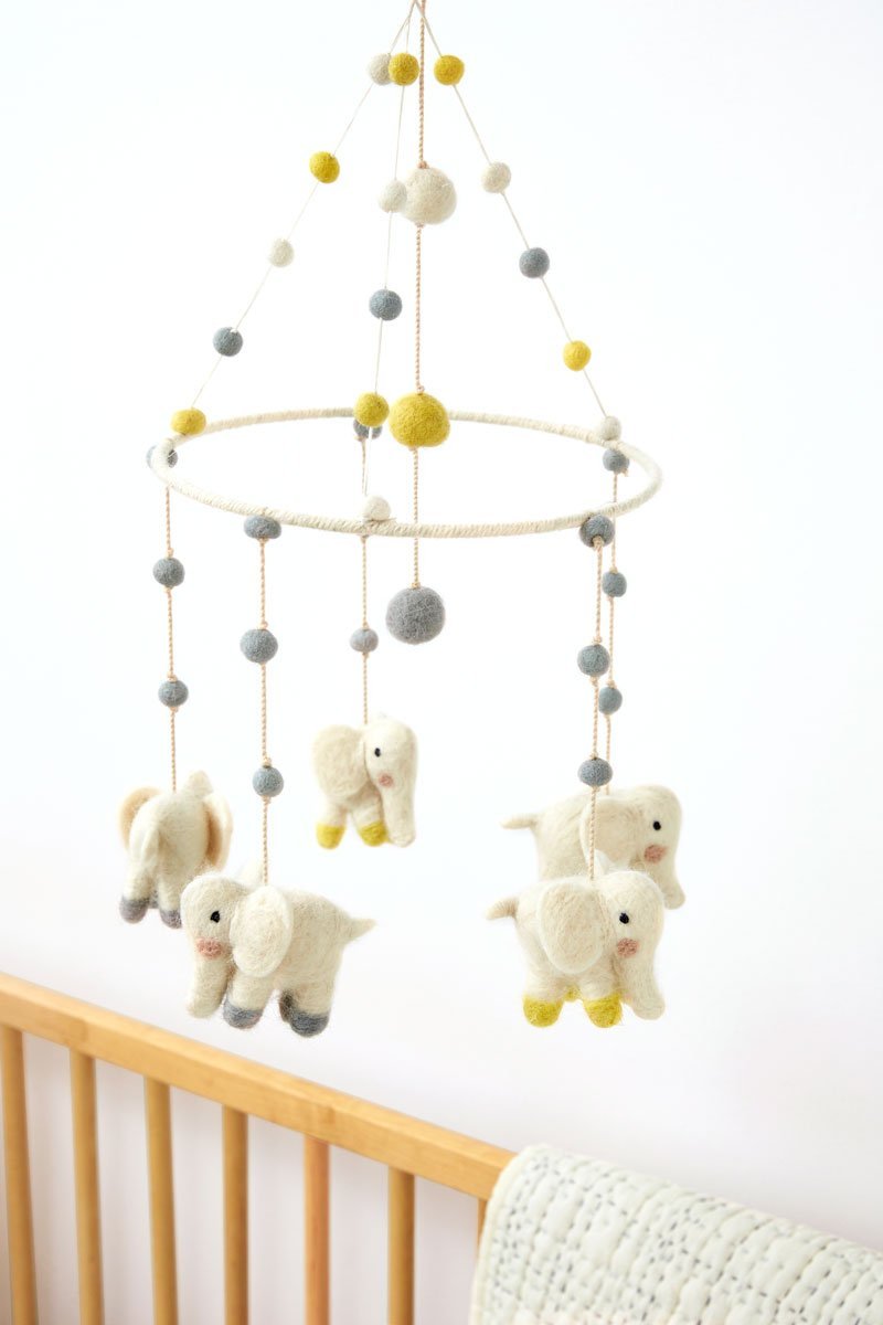 Pehr Elephant Parade Classic Mobile hanging over crib. Ethically Handmade using 100% wool and AZO-Free dyes. Mobile with Elephants.