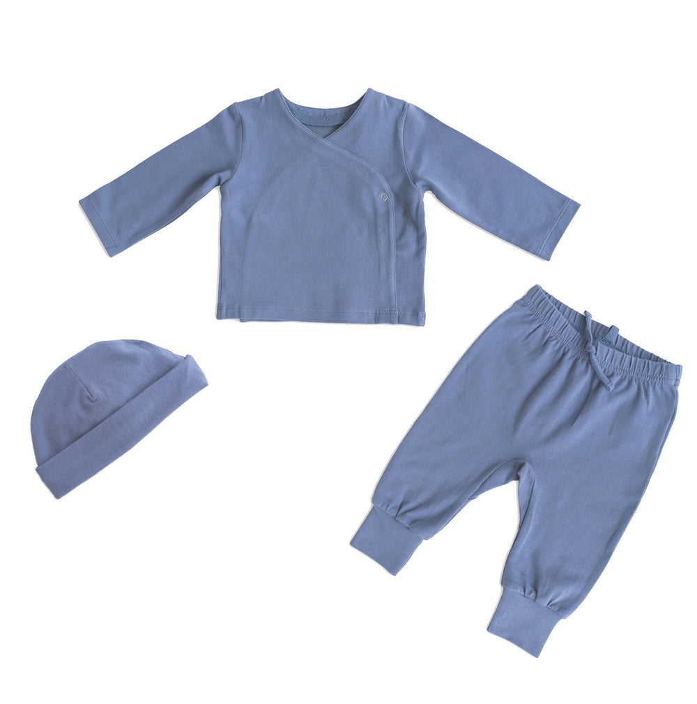 Pehr Cloud Blue 3-Piece Set. Organic. Medium blue Pehr Essentials wrap cardigan, Pehr Essentials pant, and Pehr Essentials Hat.