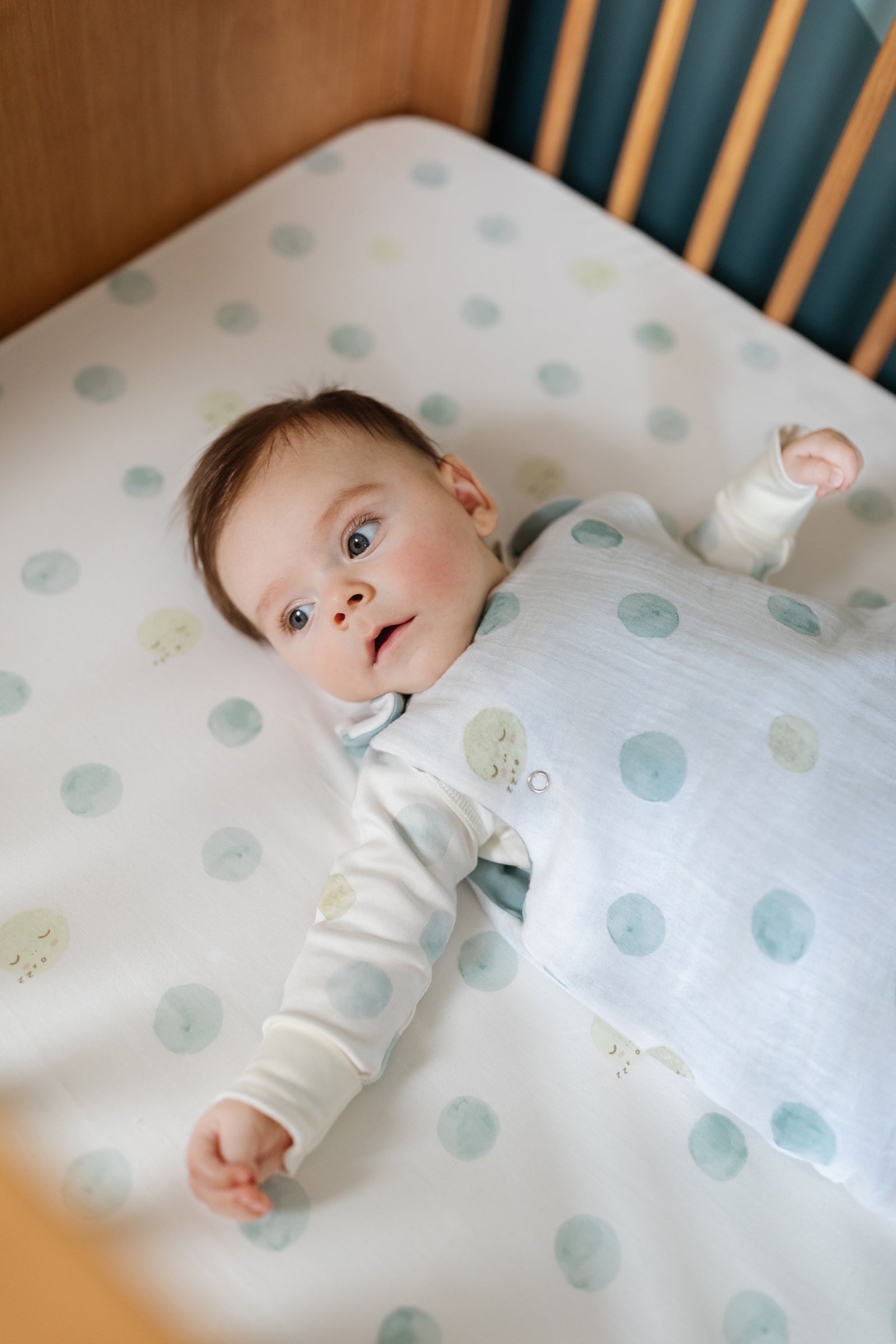 Baby laying in crib wearing Luna Dusk Sleep Bag in size 0-9mos