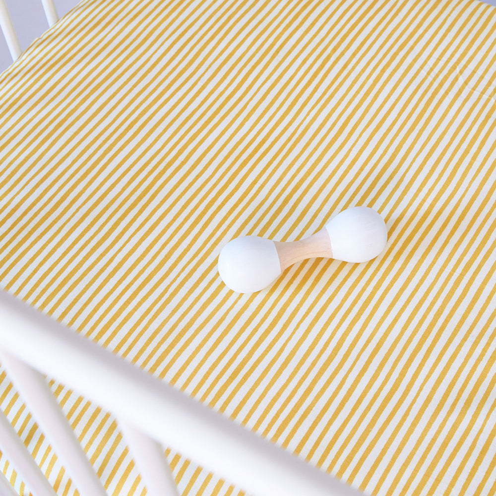 Pehr Stripes Away Marigold Organic Striped Crib Sheets. GOTS Certified Organic Cotton. White with gold stripes, shown close up.