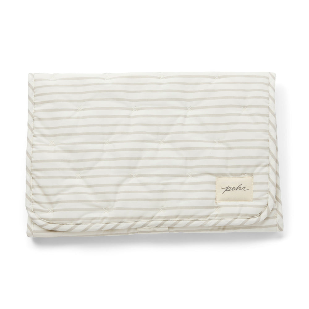 Pehr Pebble Organic On The Go Travel Change Pad folded. GOTS Certified Organic Cotton & Dyes. White with light grey stripes.