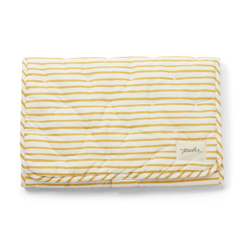 Pehr Marigold Organic On The Go Travel Change Pad folded. GOTS Certified Organic Cotton & Dyes. White with gold stripes.